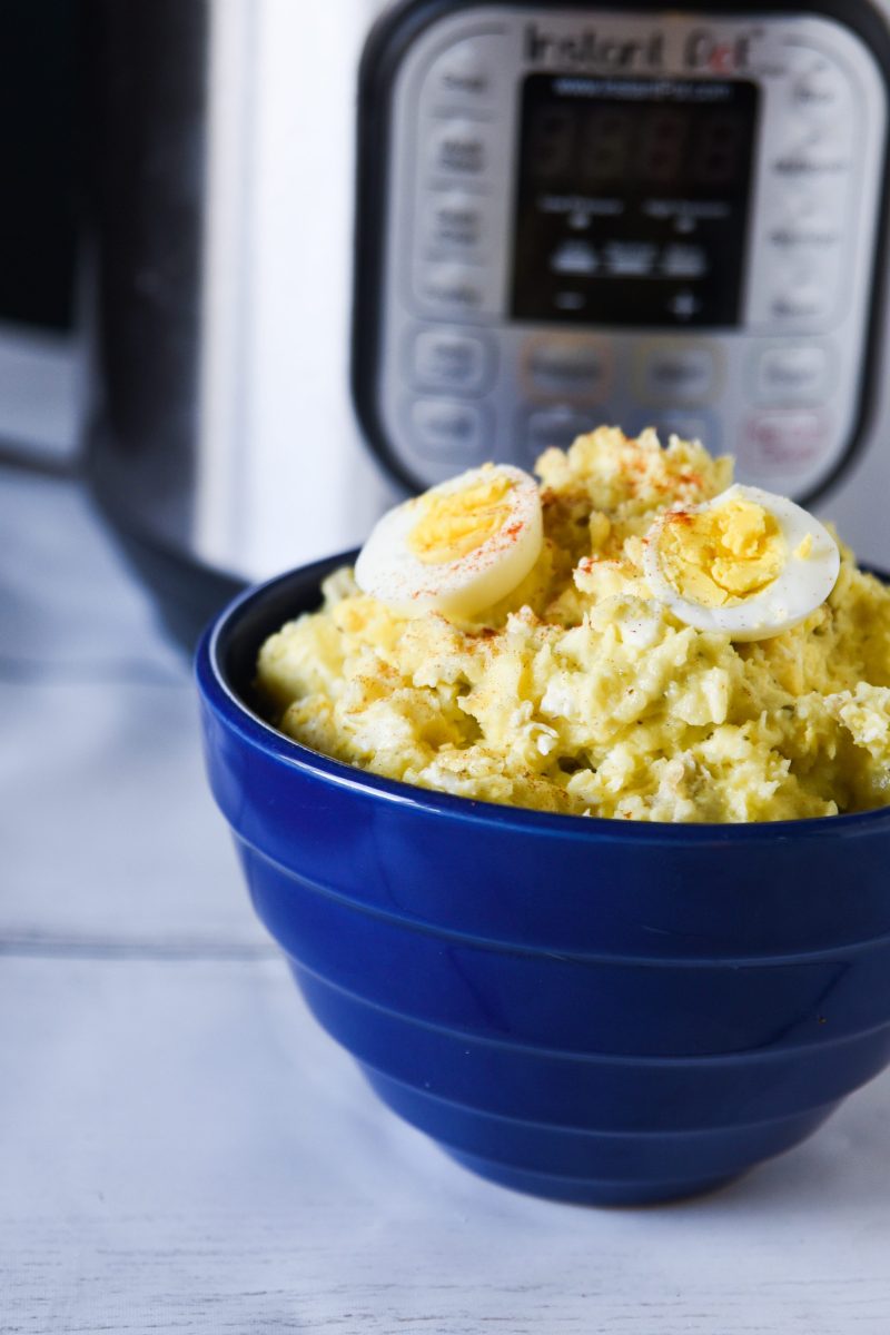 closeup of potato salad in a blue bowl in front of instant