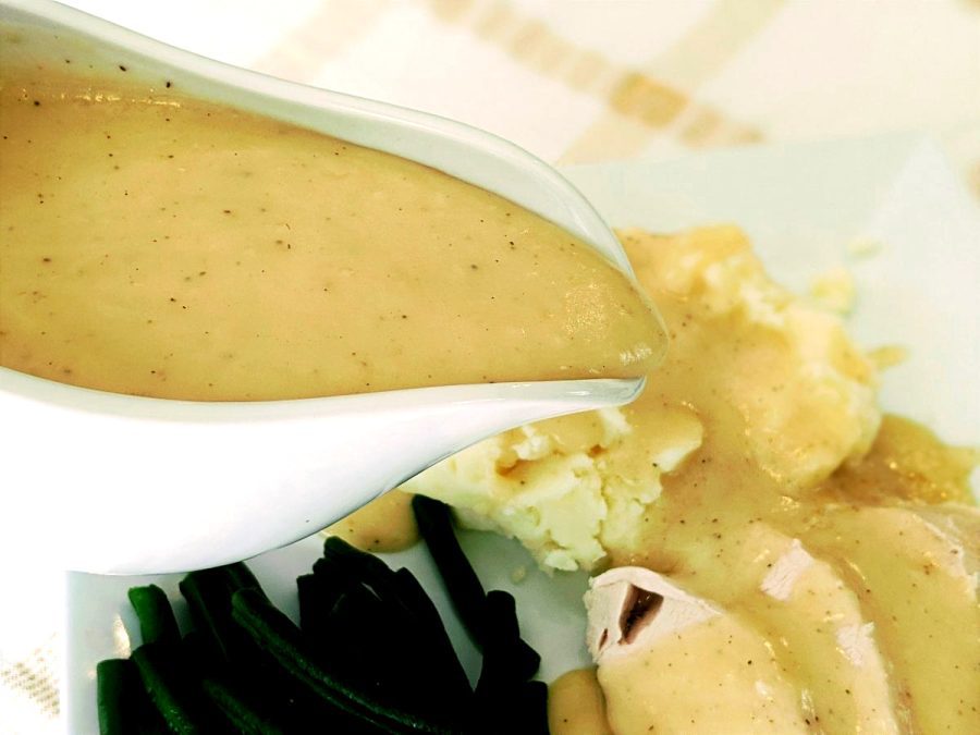 pouring turkey gravy over mashed potatoes