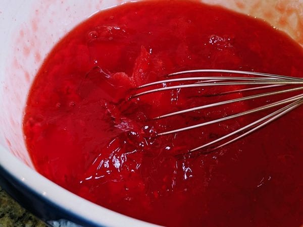 mixing strawberries into jello