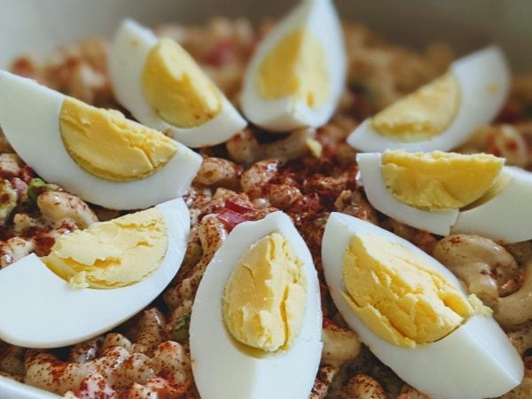 hard boiled eggs on top of macaroni salad