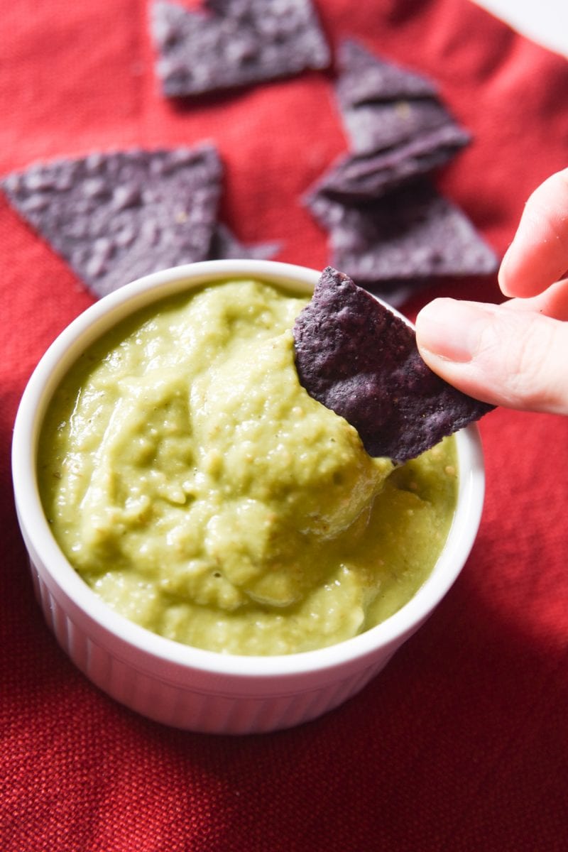 dipping a chip in guacamole salsa