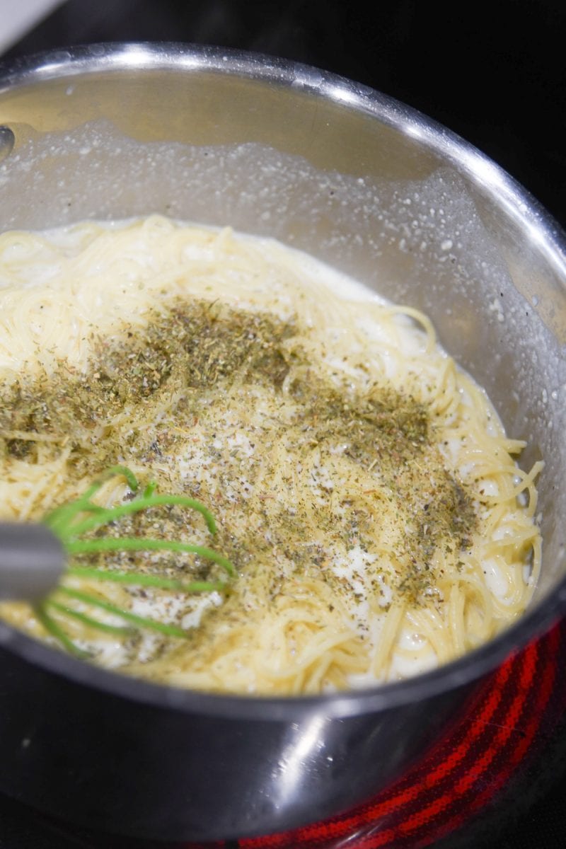 mixing pasta with herbs