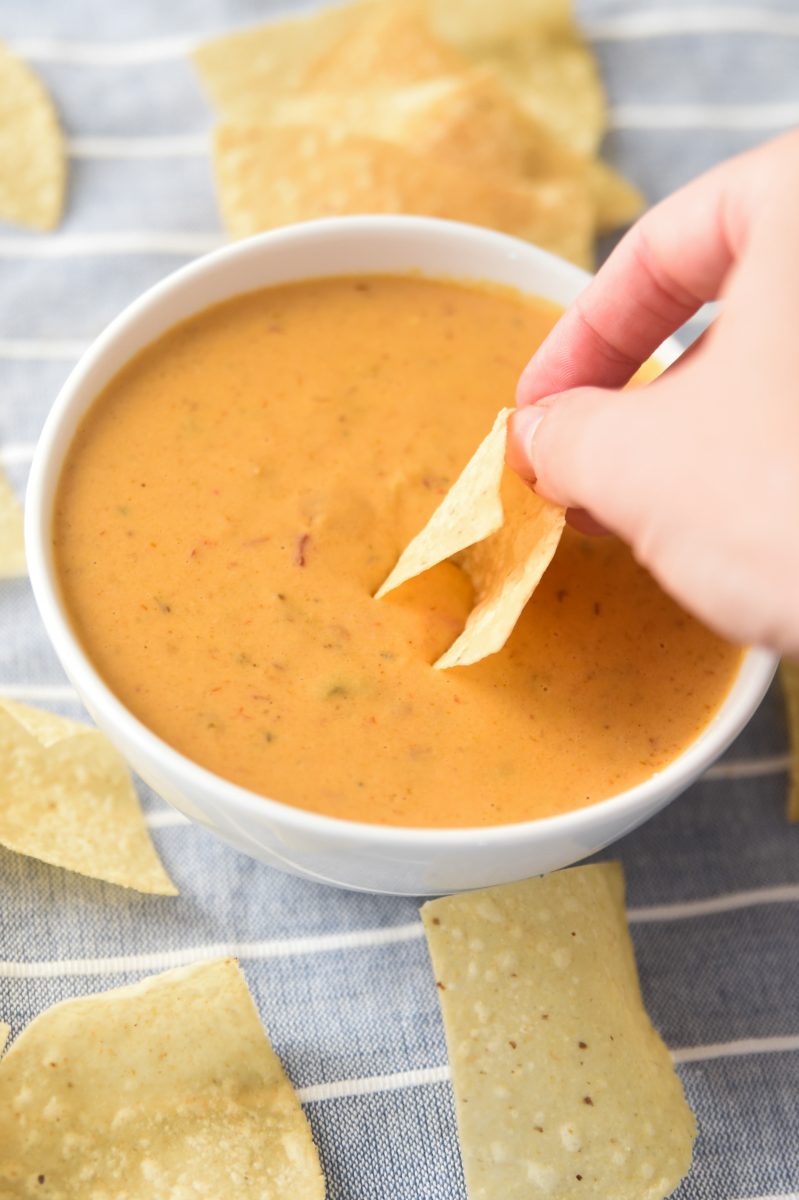 dipping chip into chuy's queso