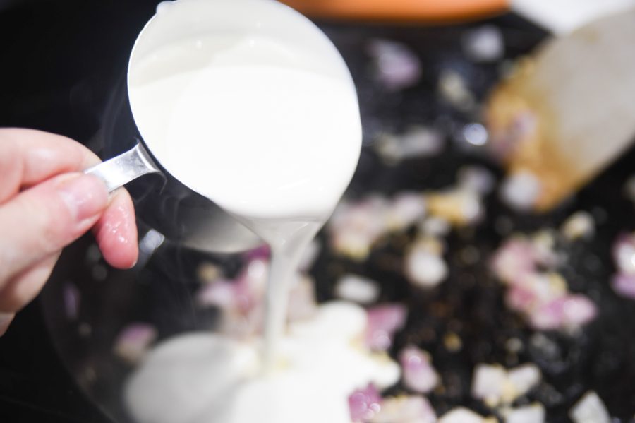 pouring heavy cream into a pan