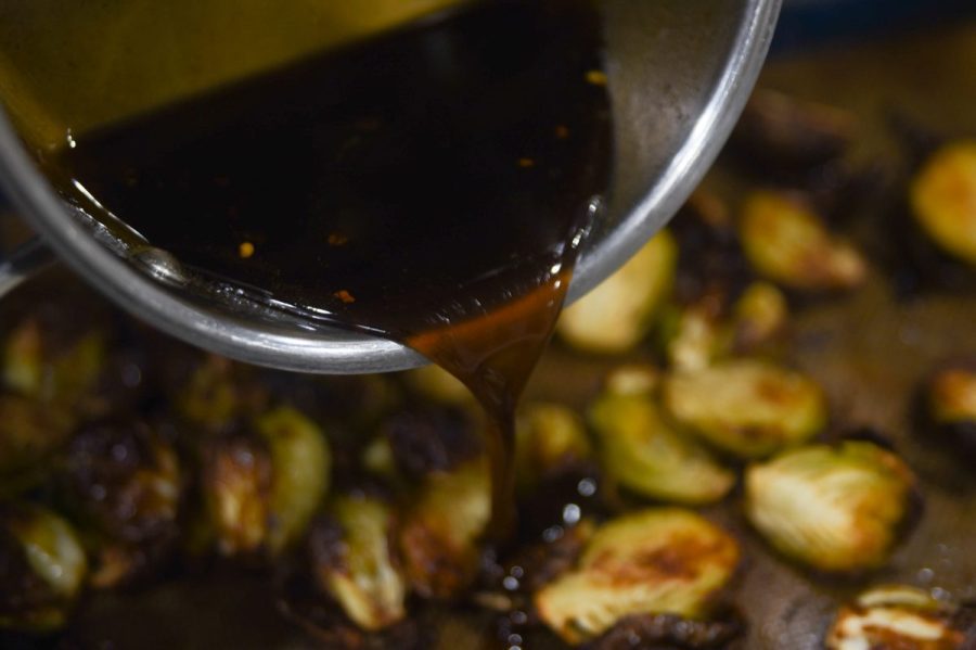 pouring sauce on brussel sprouts