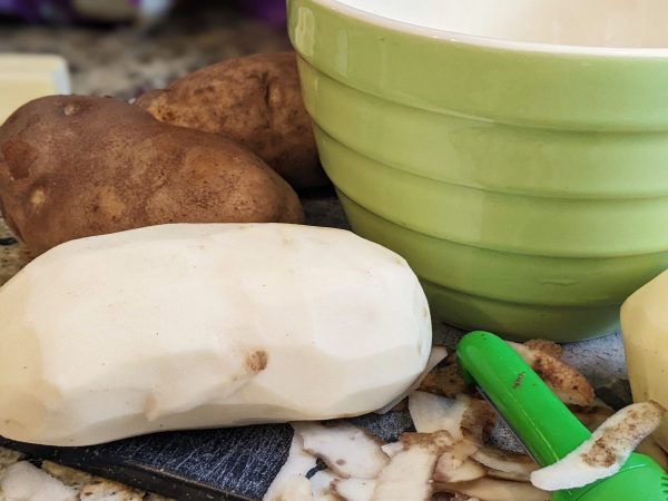 peeled potato in front of a bowl