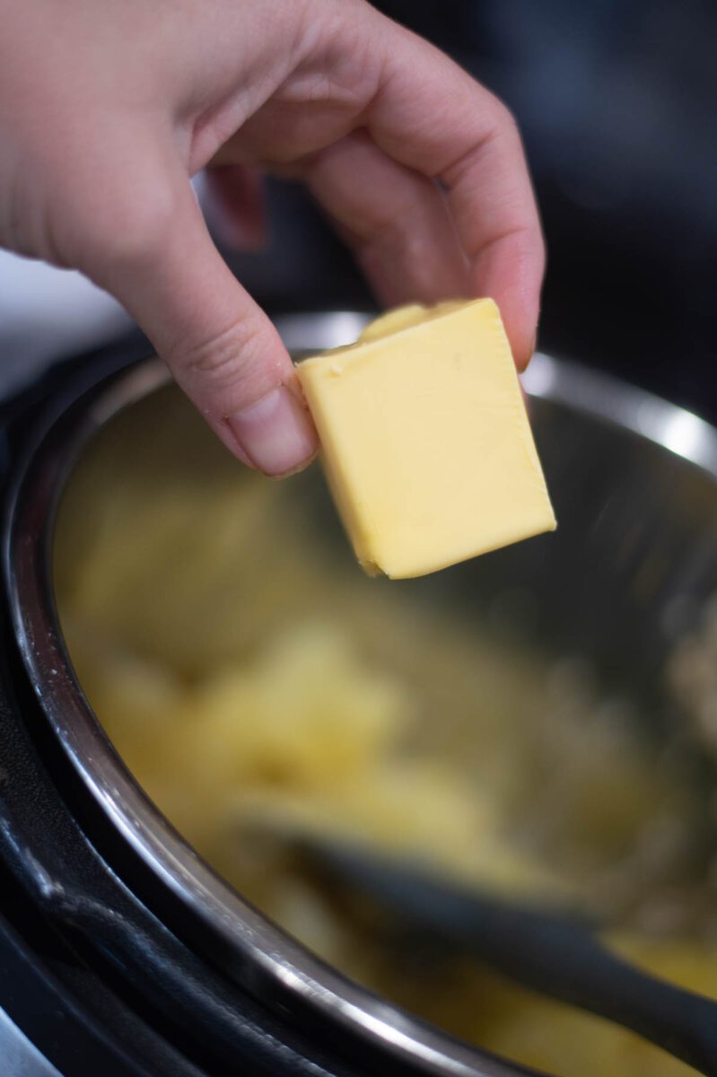 putting butter into potatoes