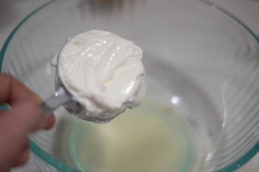greek yogurt being poured into a bowl 