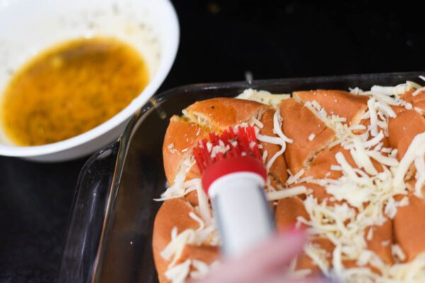 brushing hawaiian rolls with butter