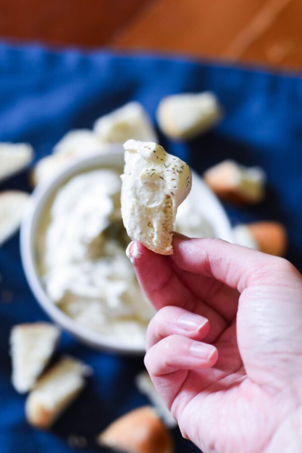 piece of bread dipped in bagel dip